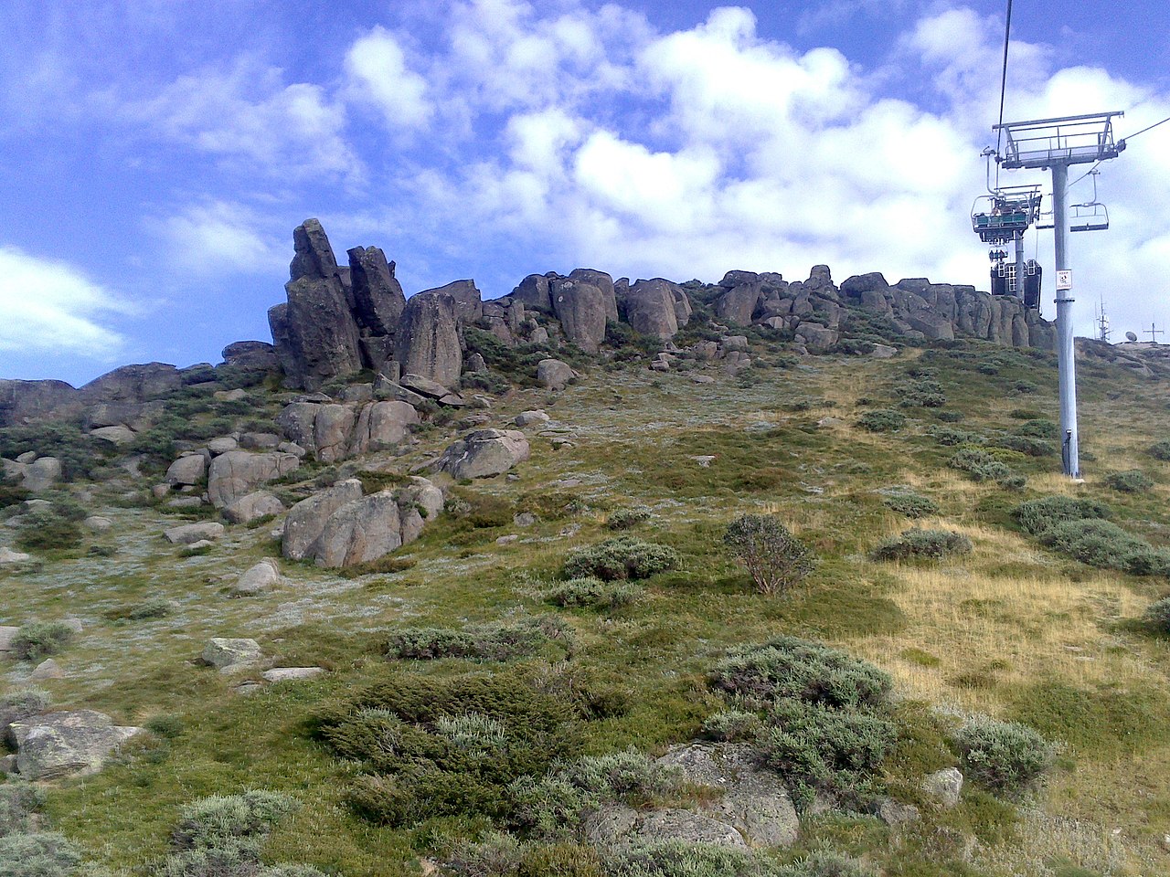 Pristine alpine landscape with rolling green hills and mountain peaks